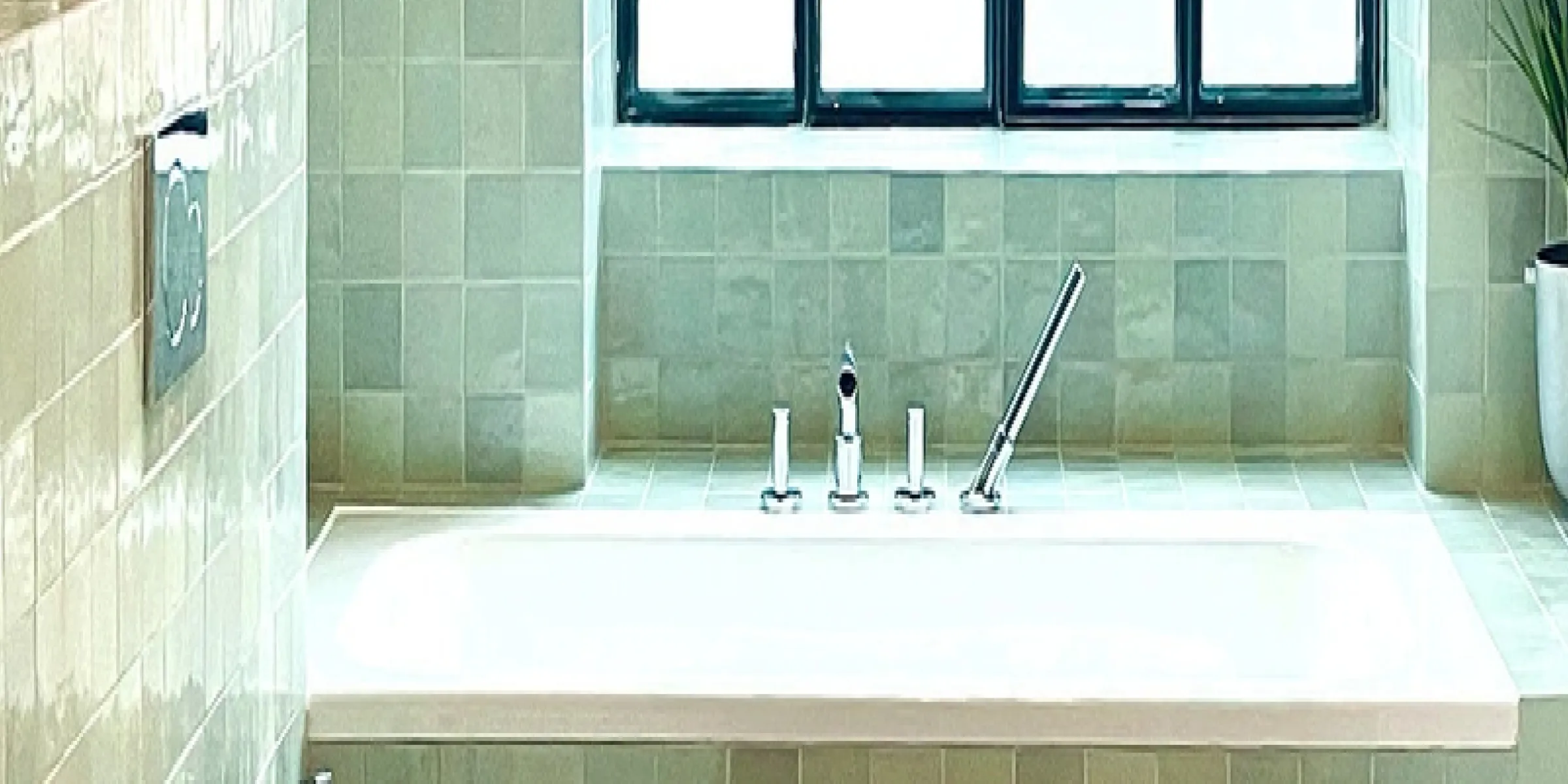 Grün gefliestes Badezimmer mit Badewanne