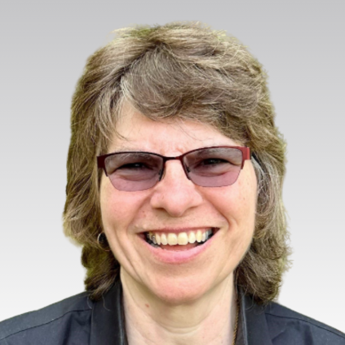 Lisa Coffelt. RISA Representative. Woman with short hair in front of grey background.