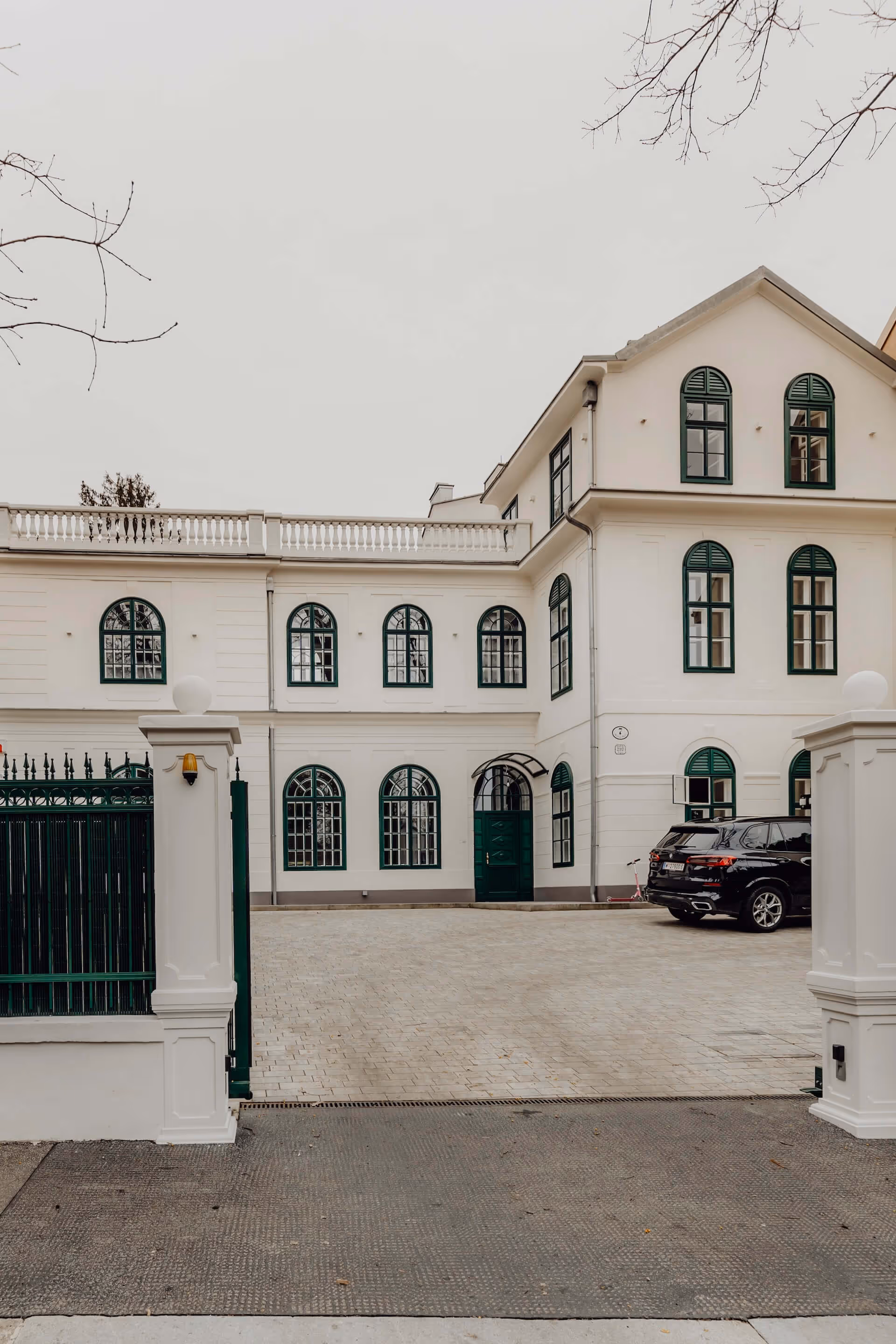 Saniertes historisches Wohnhaus in der Weidlichgasse mit grün gerahmten Fenstern und neu gestalteter Einfahrt.