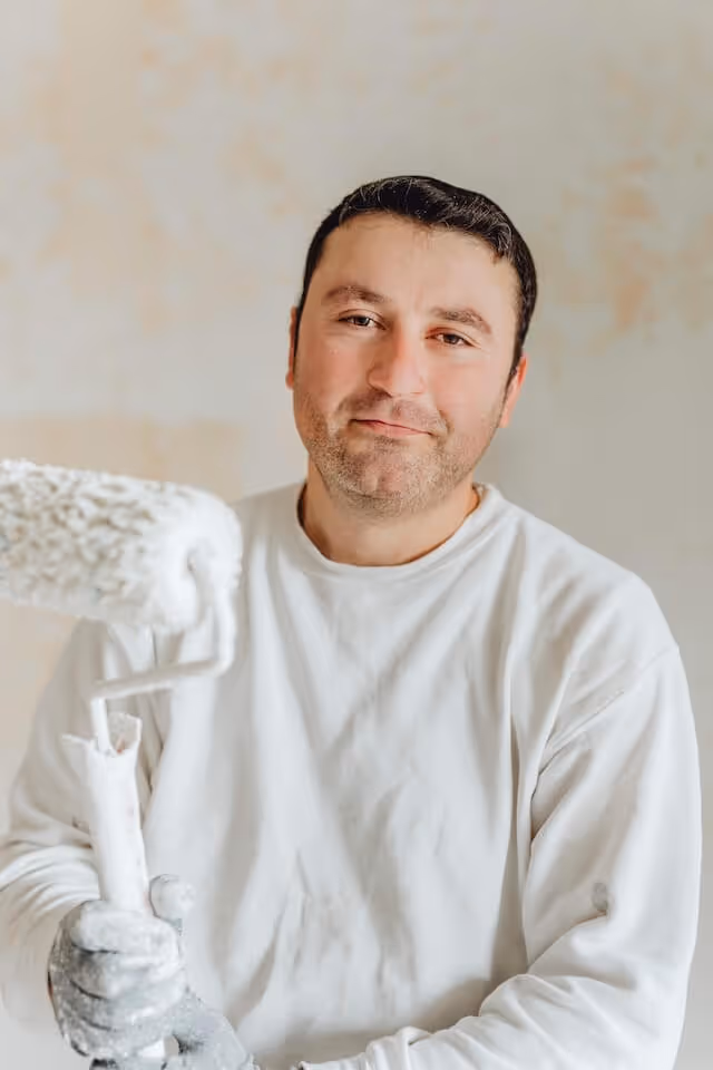 Handwerker in weißem Maler-Outfit.