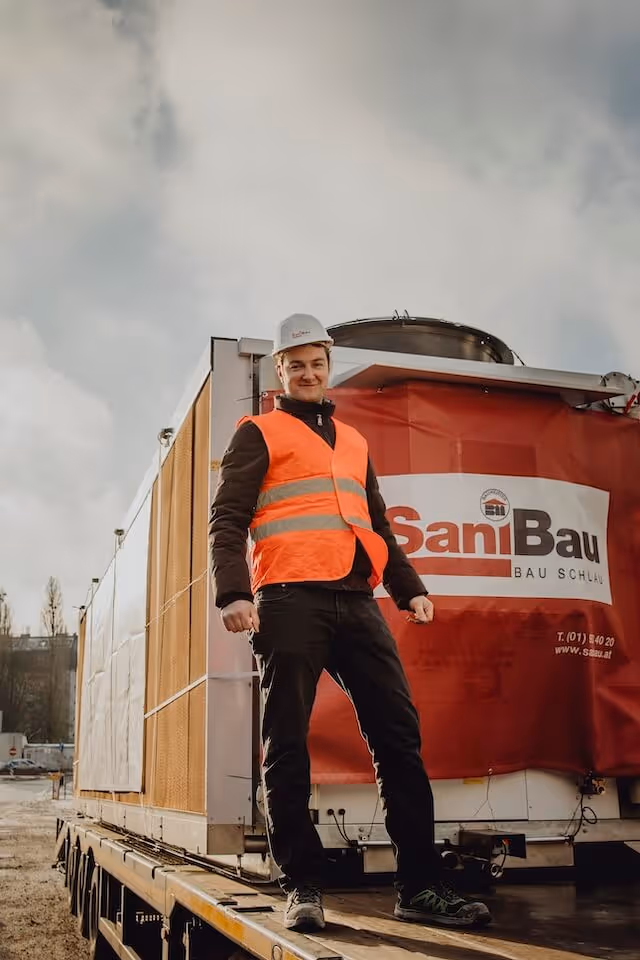 Bauarbeiter vor SaniBau Bagger bei Erdarbeiten.