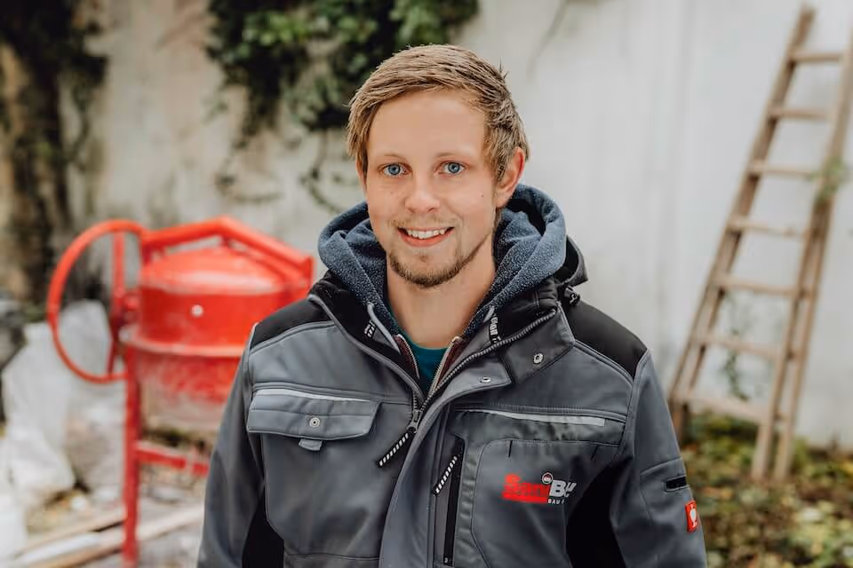 Handwerker von SaniBau bei Arbeiten im Außenbereich.