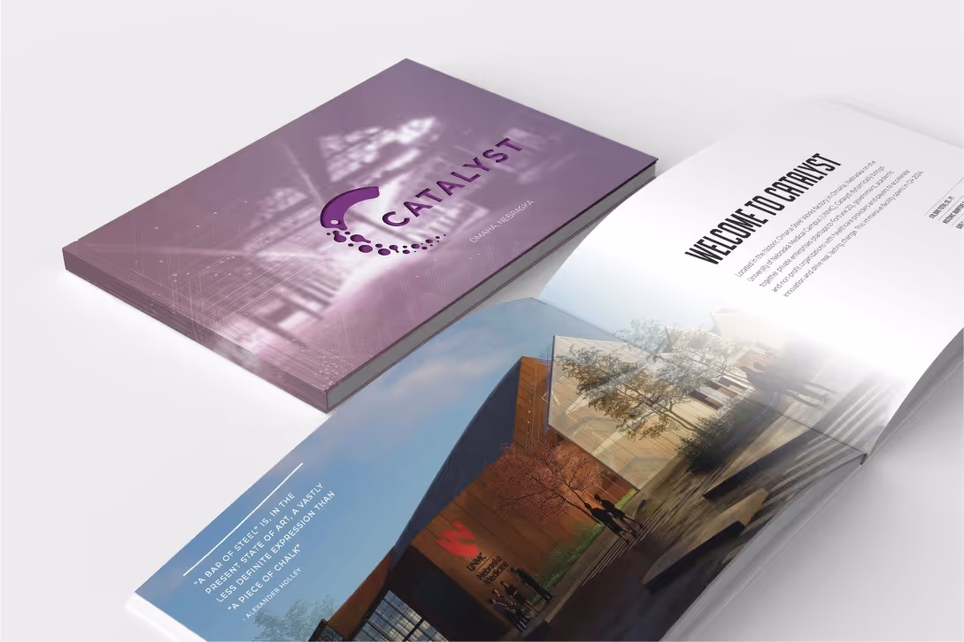 Purple book titled 'Catalyst' beside an open spread showing a modern building and text 'Welcome to Catalyst'.