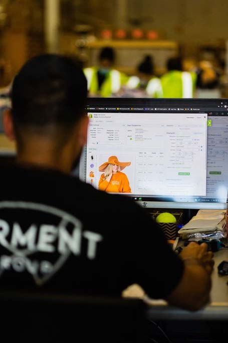 A man wearing a black shirt is looking at a computer screen.