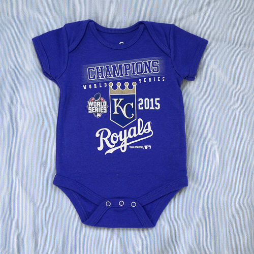a Kansas City Royals MLB blue baby bodysuit with white text on it