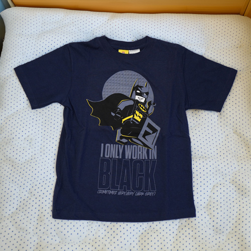 a blue Batman shirt on a bed