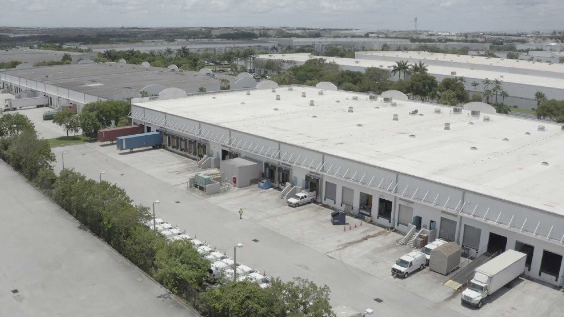 a large warehouse with trucks parked outside