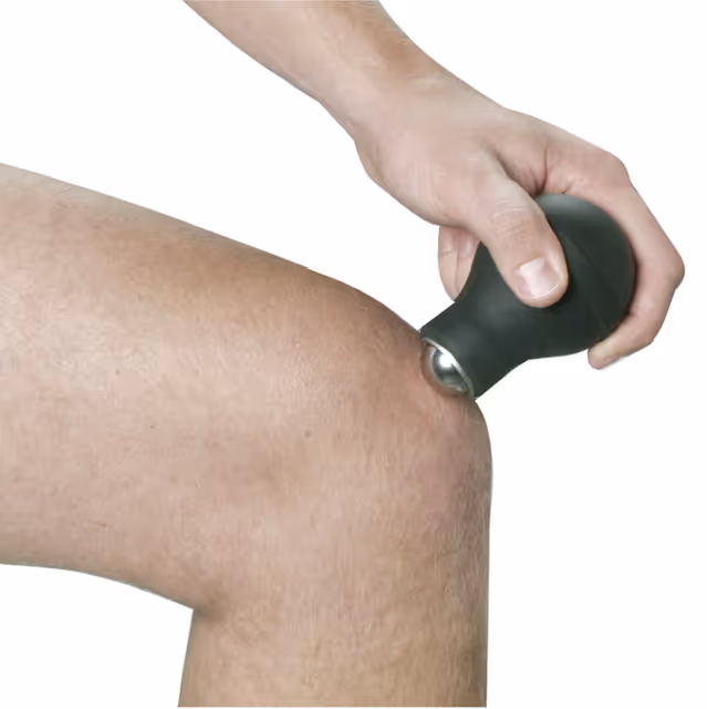 Hand using massage tool on knee for muscle relaxation or pain relief