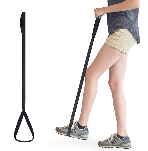 Person stretching leg with long resistance band in exercise studio