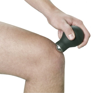 Hand using massage ball on knee for muscle relief or therapy