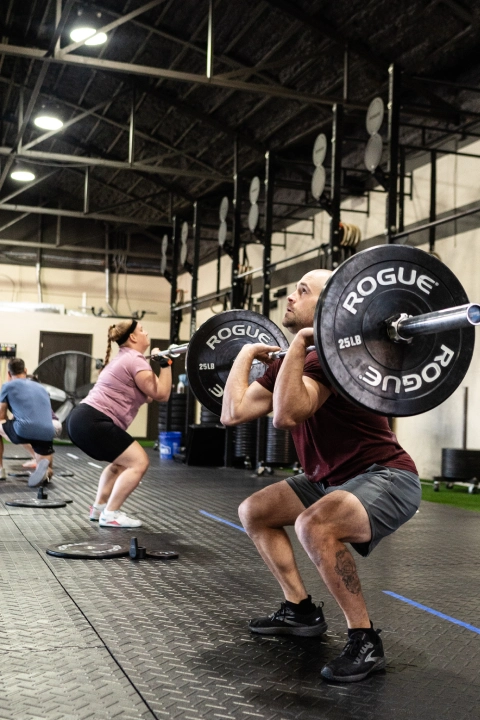 Strength & Conditioning gym interior at TriPower Strength & Conditioning in Eustis, FL, showcasing workout equipment and athletes in action.