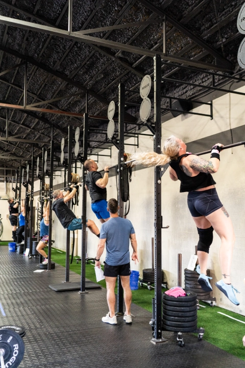 Strength & Conditioning gym interior at TriPower Strength & Conditioning in Eustis, FL, showcasing workout equipment and athletes in action.