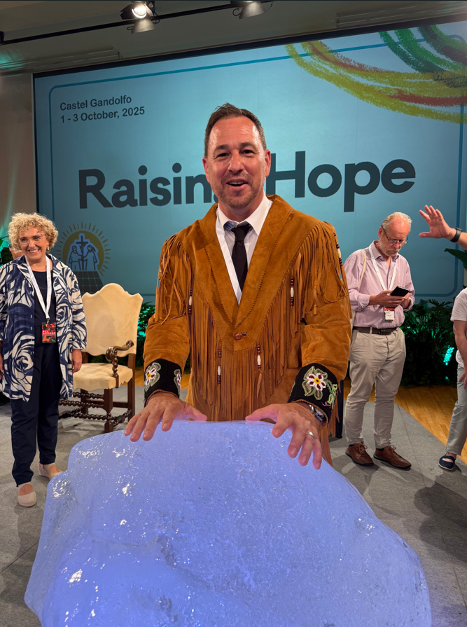 Jeff Cyr poses with a piece of an iceberg at The Vatican's Raising Hope climate event
