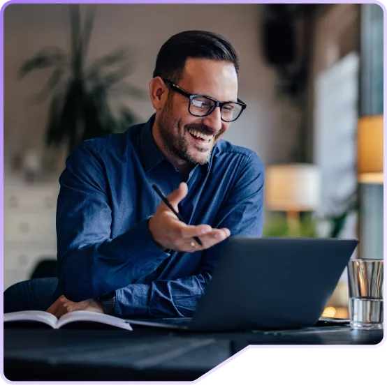 Foto de um homem olhando para seu notebook, feliz e satisfeito.