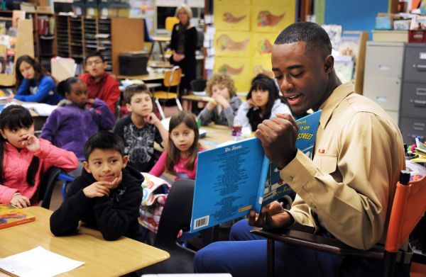 A service member with a book in a classroom