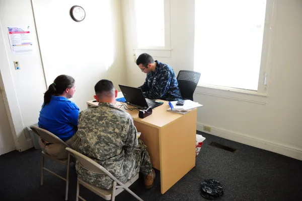Service members at desks at a base tax-assistance center