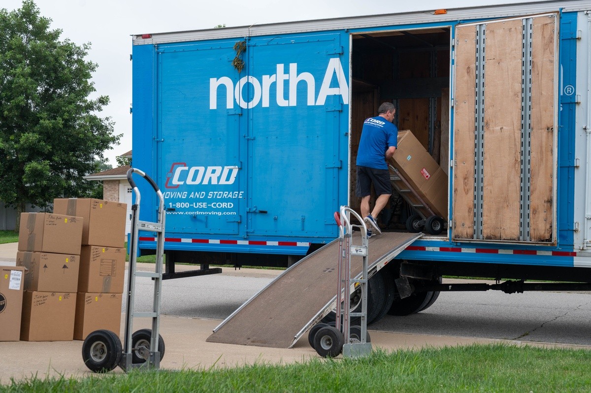 A moving truck is unloaded as a military family moves into new base housing