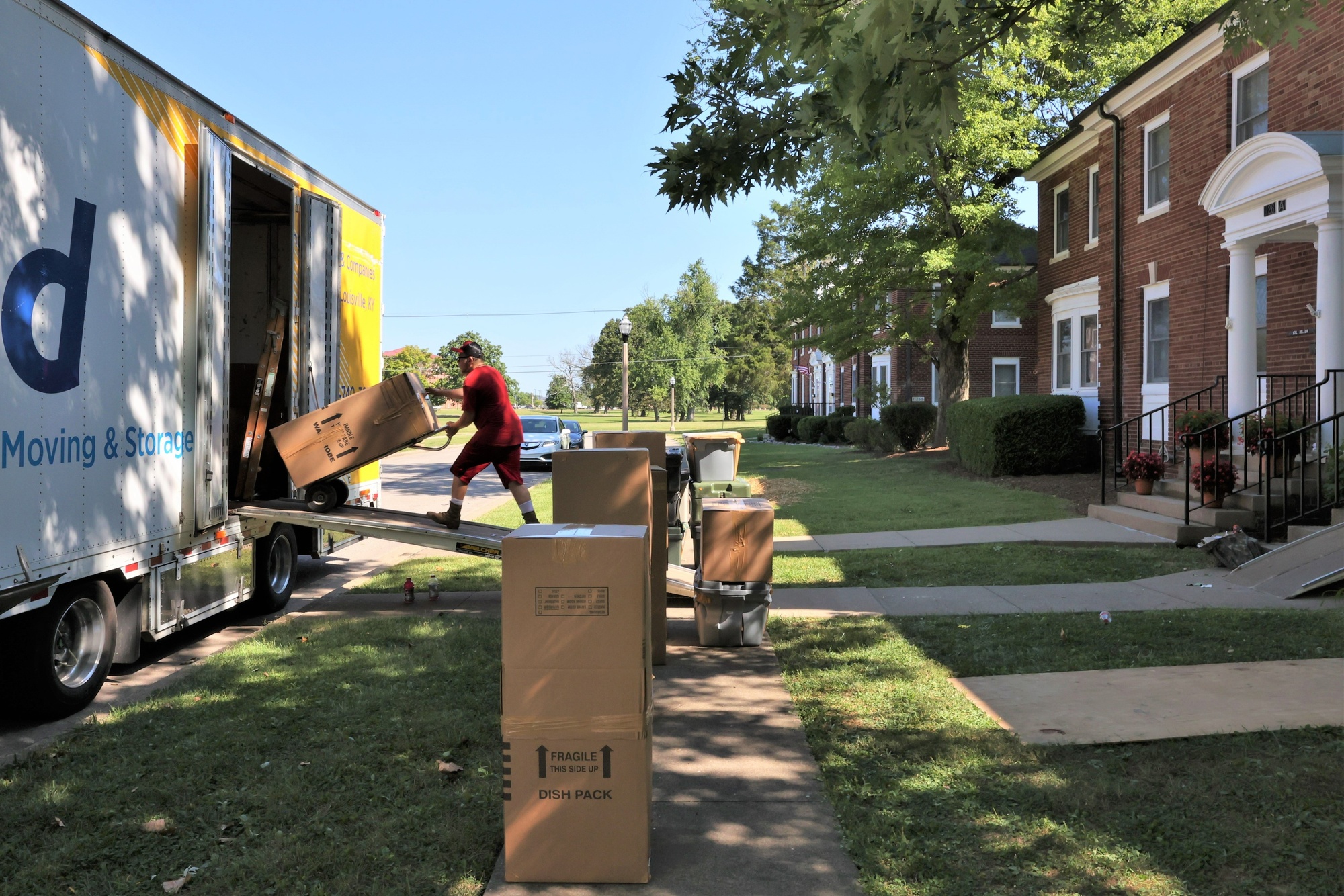 A mover loads household goods onto a moving truck outside base housing during a PCS move