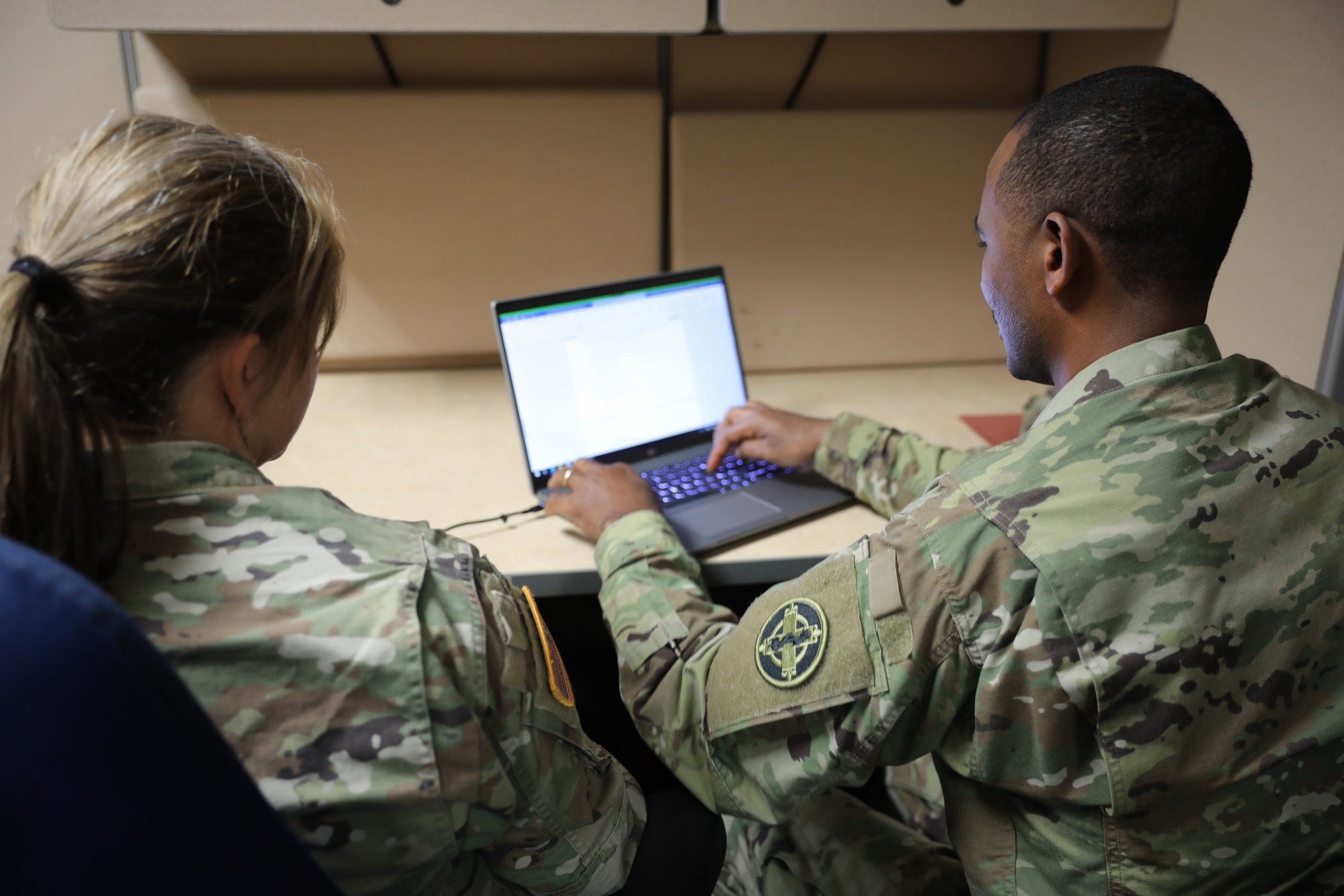 A judge advocate provides legal assistance to a soldier preparing legal paperwork