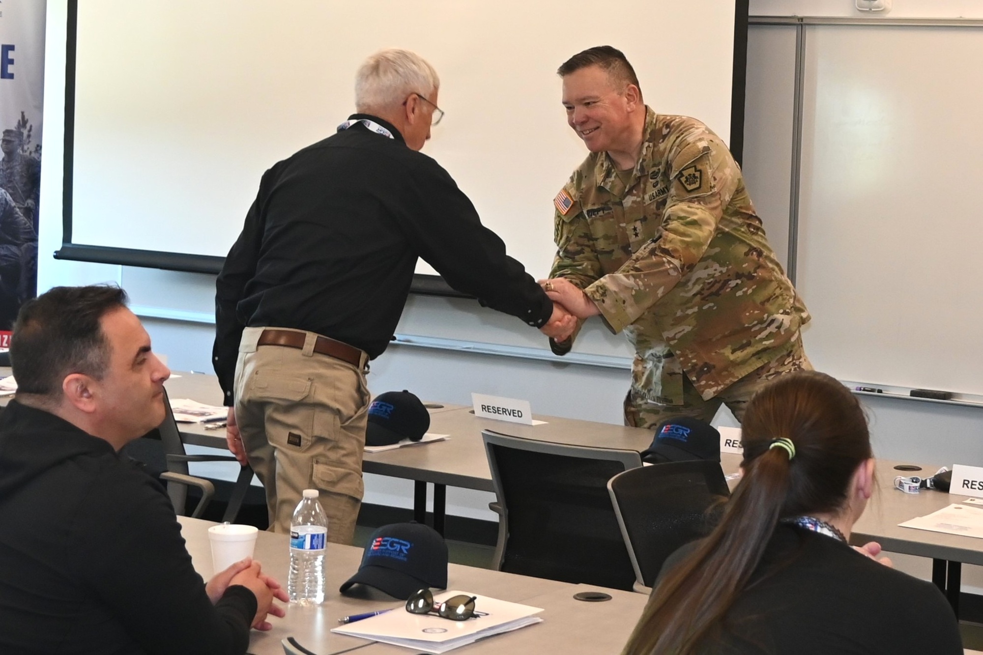 Leaders shake hands at an Employer Support of the Guard and Reserve event connecting civilian employers and service members