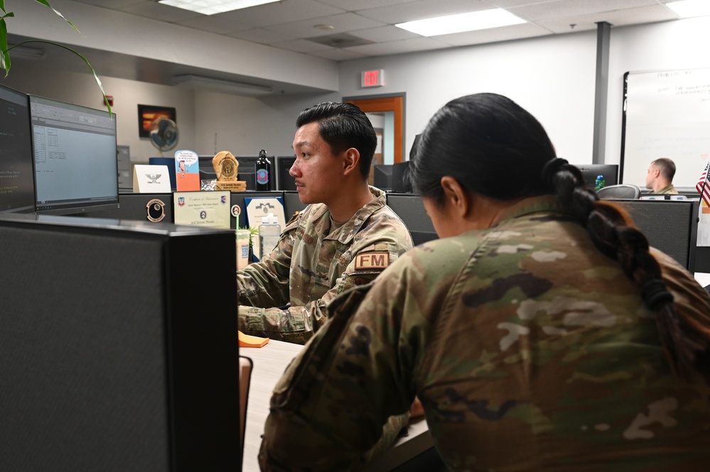 An Air Force comptroller squadron financial operations technician assists a customer at the base finance counter.