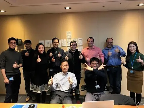 A group of Pfizer colleagues posing in front of the paper prototype we created during a 3-day hackathon in Seoul, South Korea.