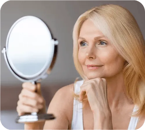 A woman looking at herself in the mirror.