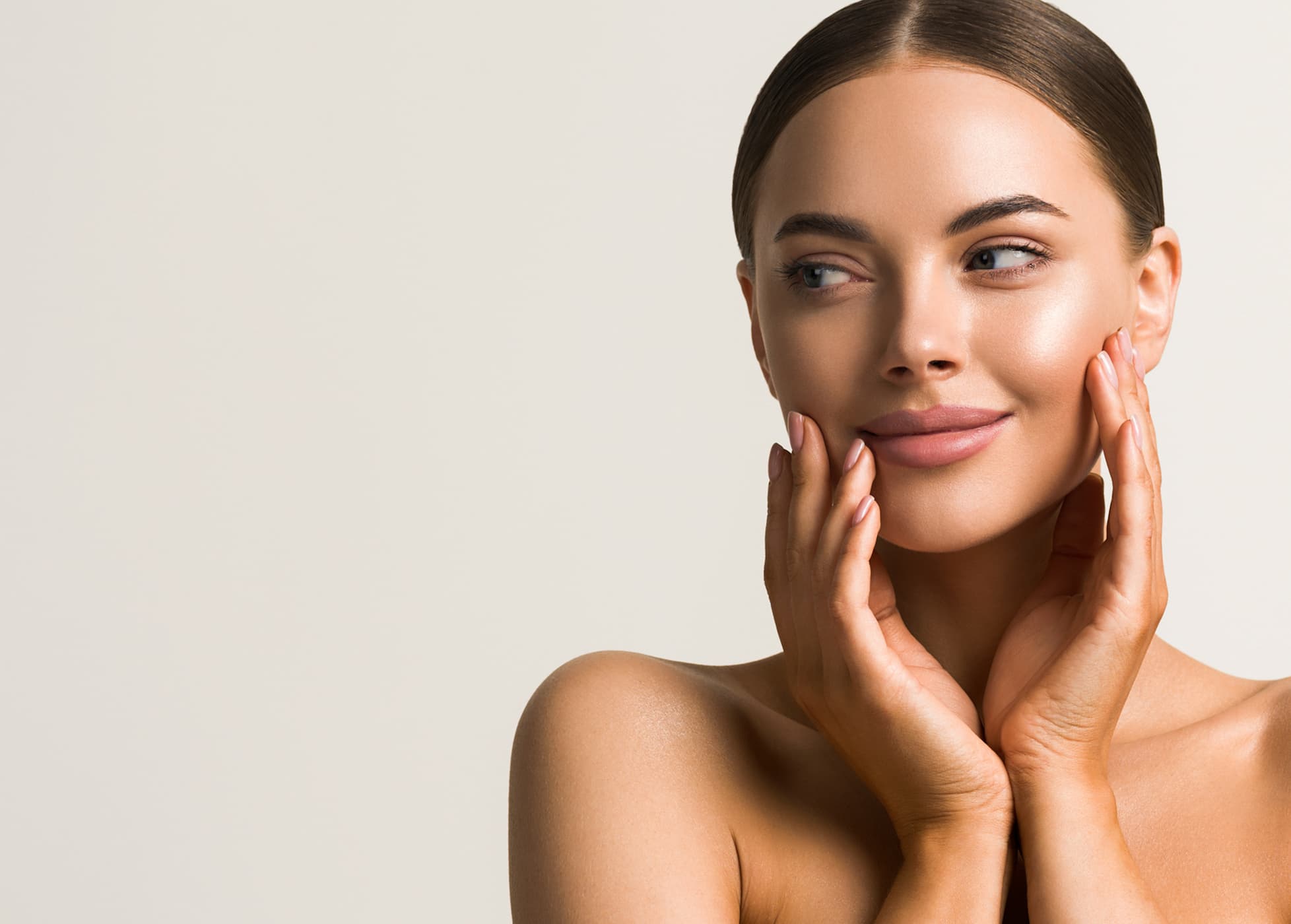 A beautiful woman posing with her hands on her face.