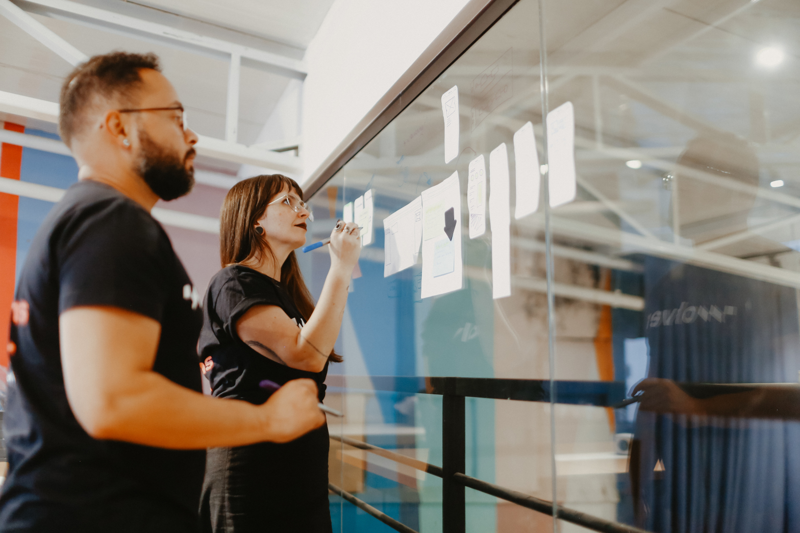 People looking at a glass white board