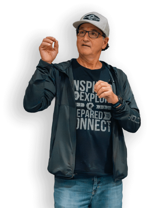 Carmine Romano presenting while wearing glasses, a gray Edge Factor cap, a black Edge Factor jacket, and a printed black Edge Factor T-shirt gesturing with his hands.