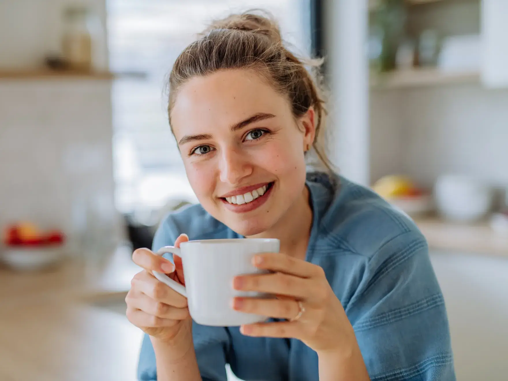 Woman smiling while looking into a tooth-shaped mirror.