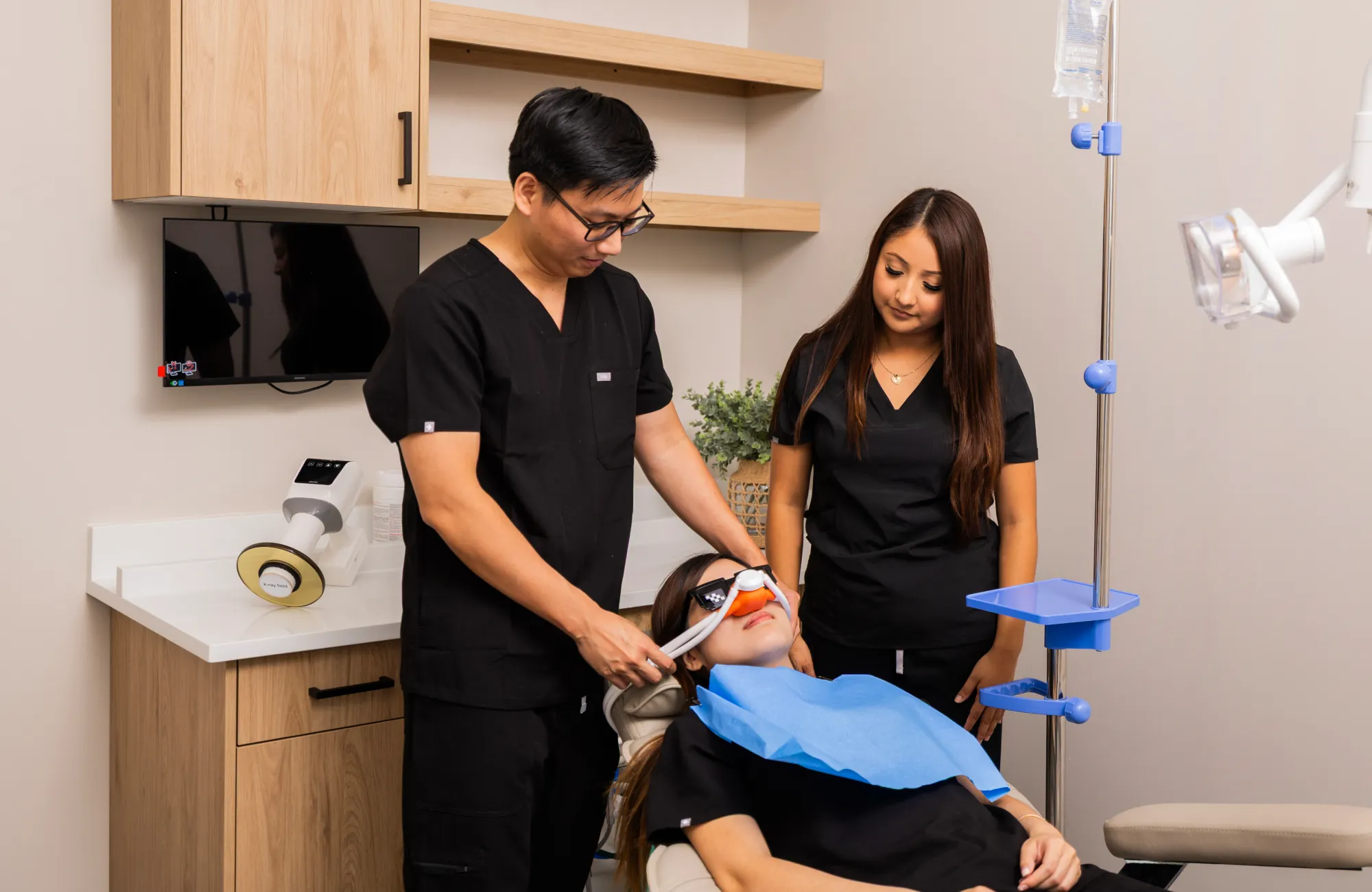 Dr. Huynh and team member adjusting patient's sedation mask