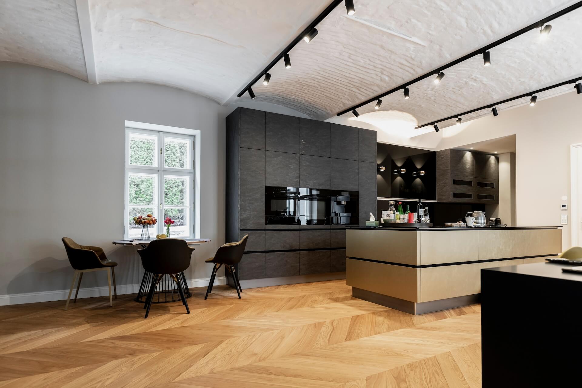 Küche mit dunklen Fronten und modernem Lichtdesign