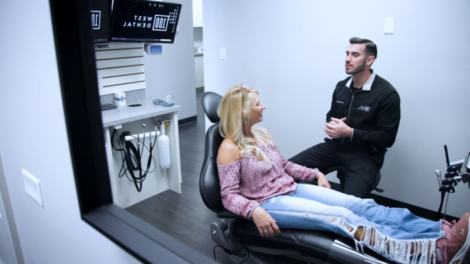 Dentist examining patient's mouth during implant treatment in clinical setting