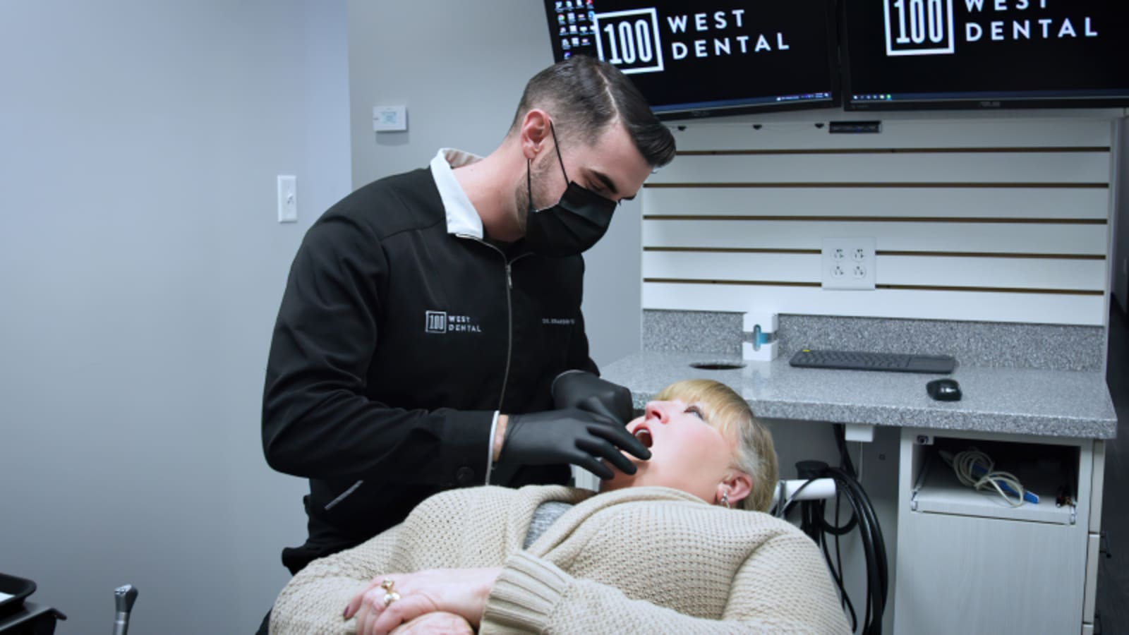 Dentist demonstrating composite veneer work on patient in treatment chair
