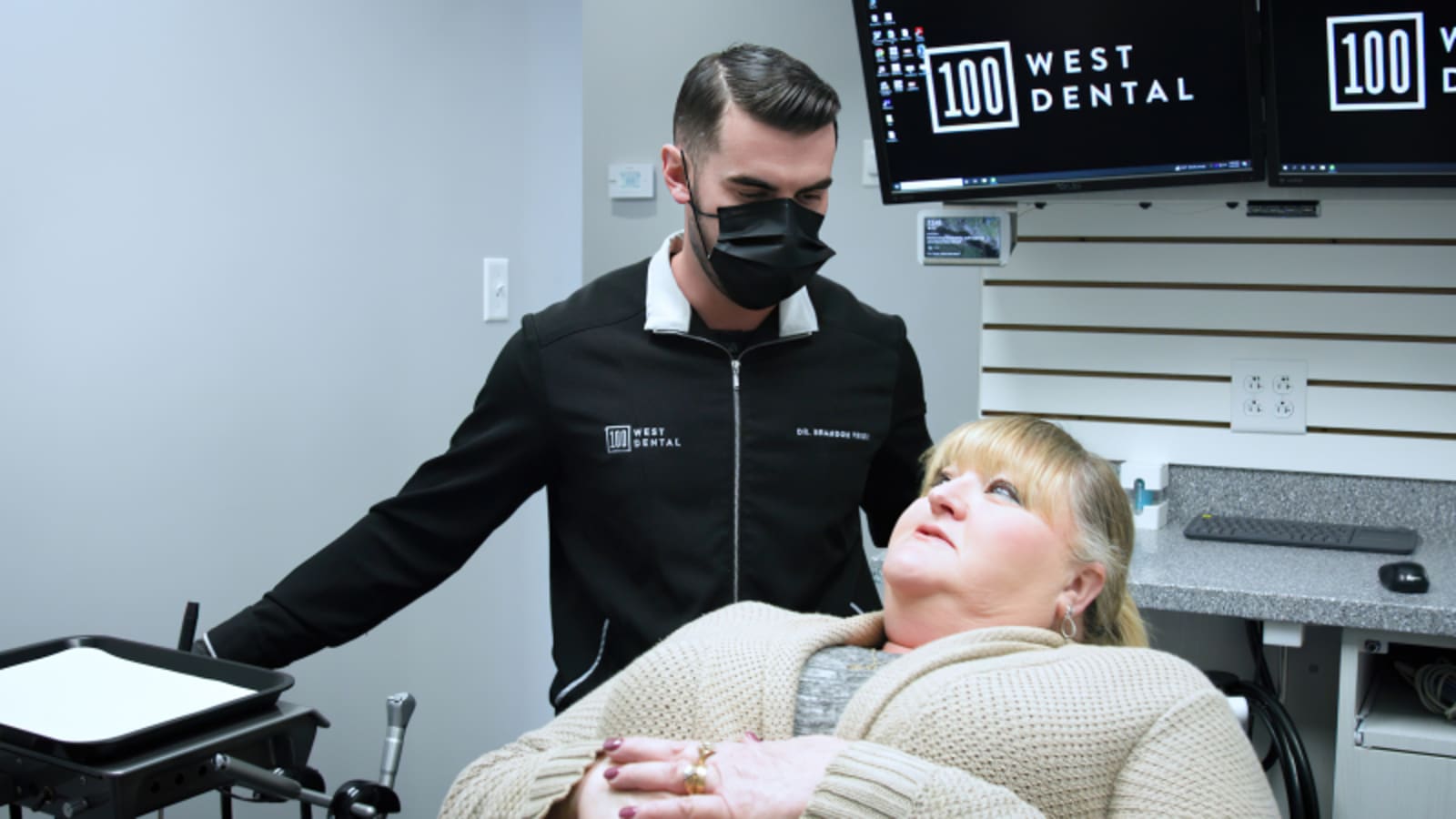 Dentist demonstrating treatment process to a patient in the treatment chair