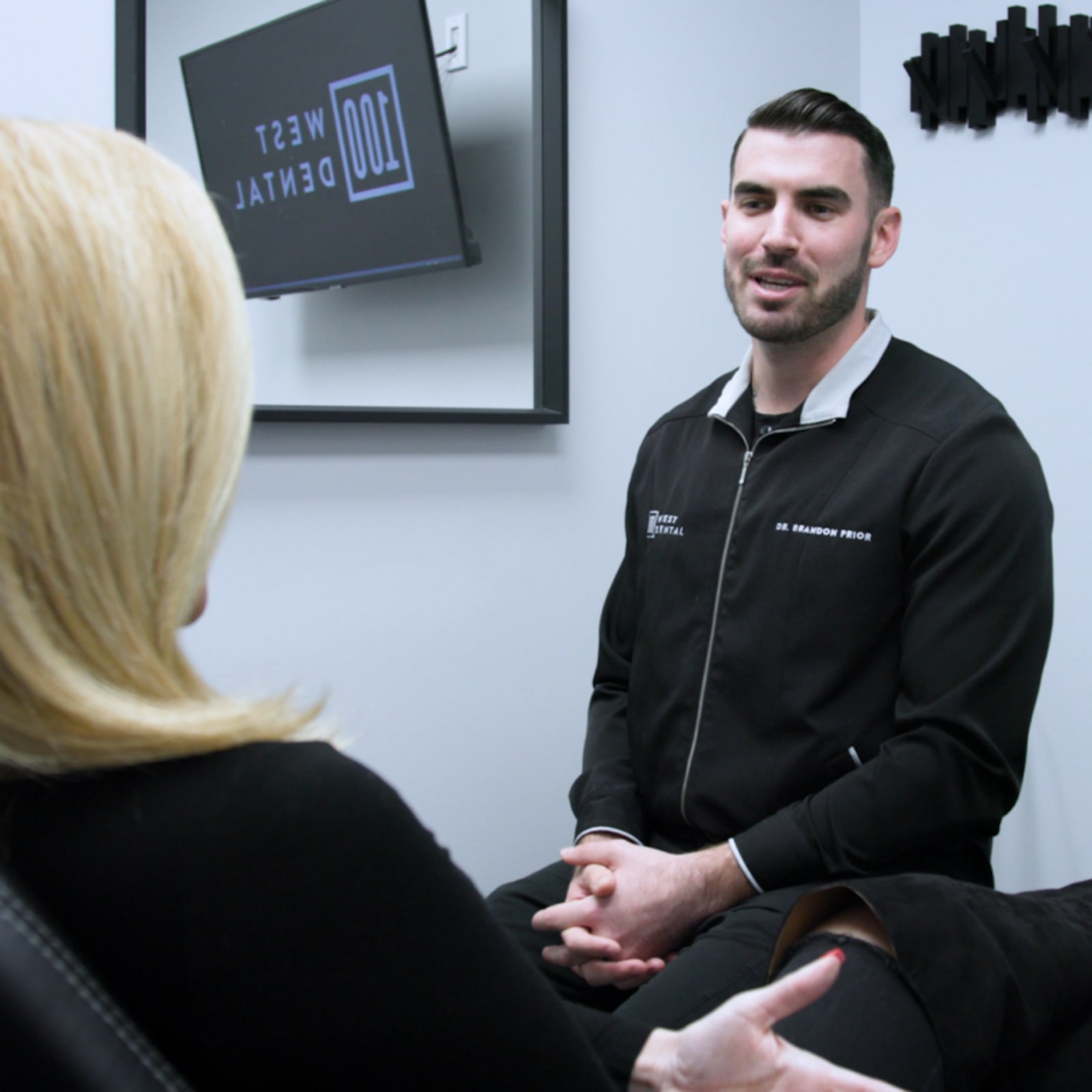 Dentist in professional attire having a consultation with a patient