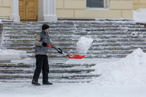 ein Mann der Schnee von der Straße räumt