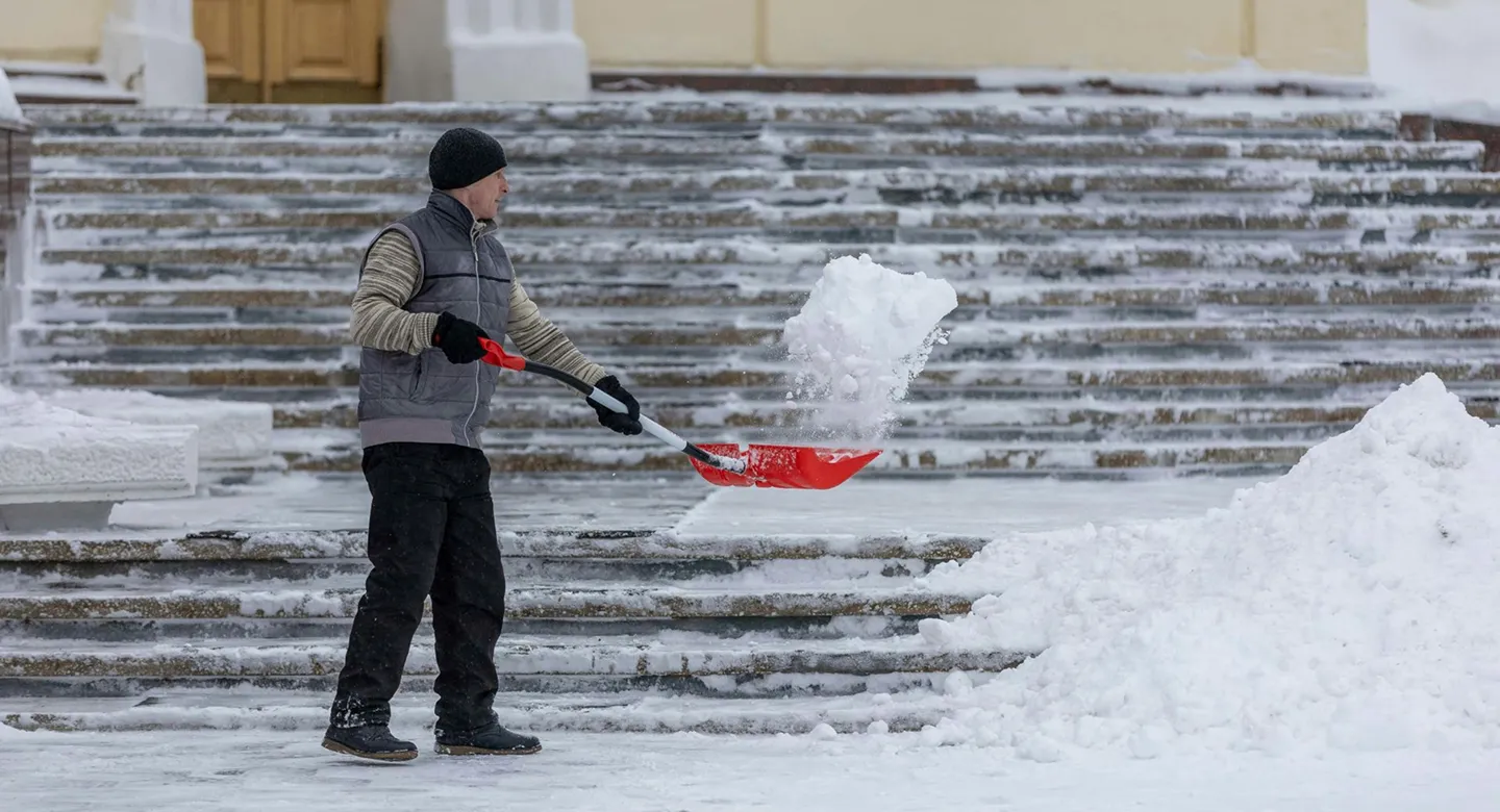 ein Mann der Schnee von der Straße räumt