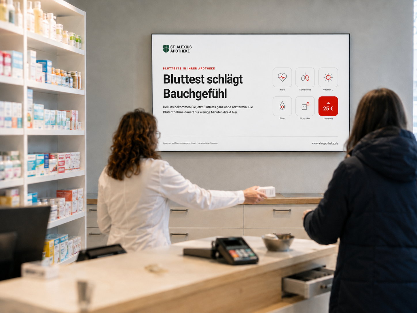 Bildschirm über der Theke zeigt das erste Motiv der St. Alexius Apotheke