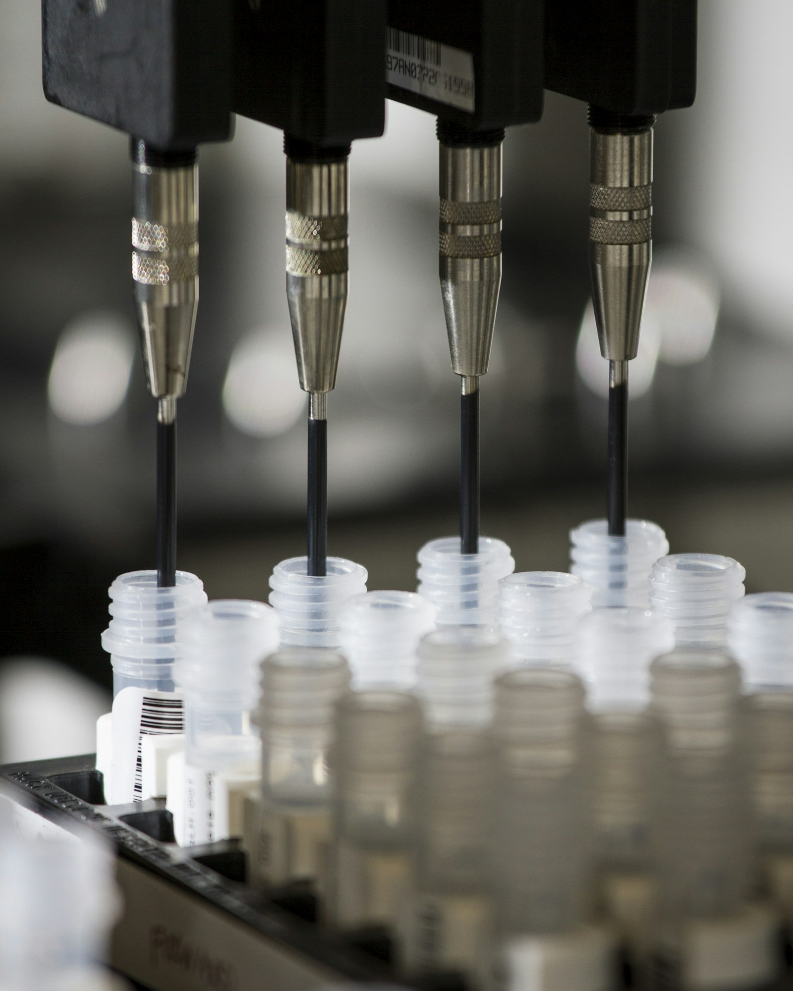 Automated pipetting heads dispensing samples into vials in a diagnostics laboratory