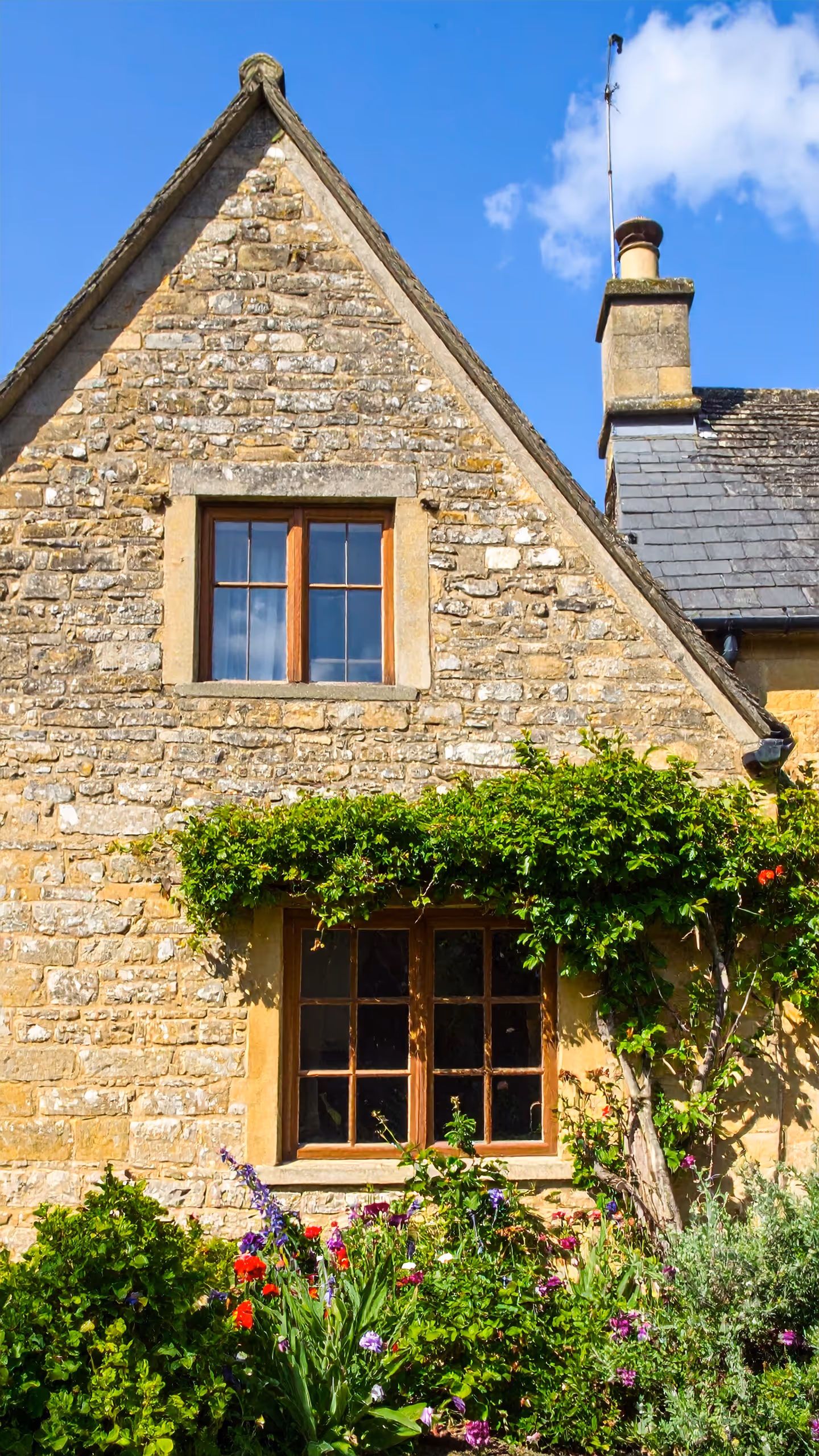 cotswold stone house with wooden timber windows