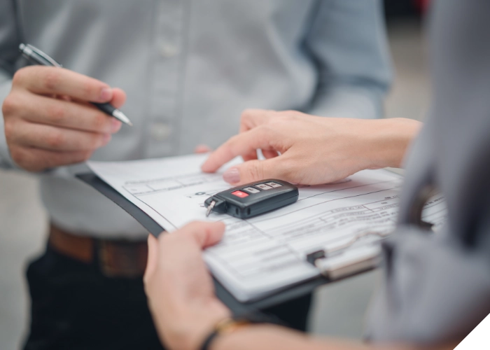 Unterschrift auf Vertragsunterlagen mit Autoschlüssel