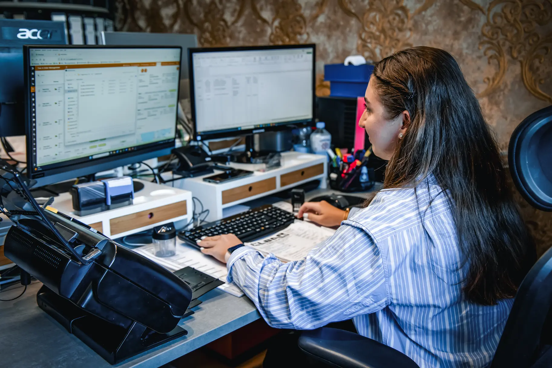 Mitarbeiterin plant Fahrzeugtransporte am Computer