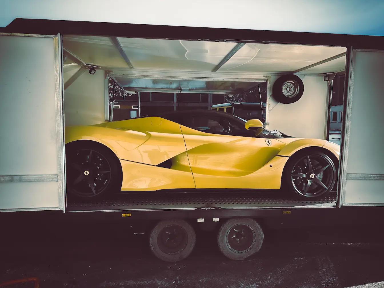 Sportwagen im geschlossenen Anhänger beim Fahrzeugtransport