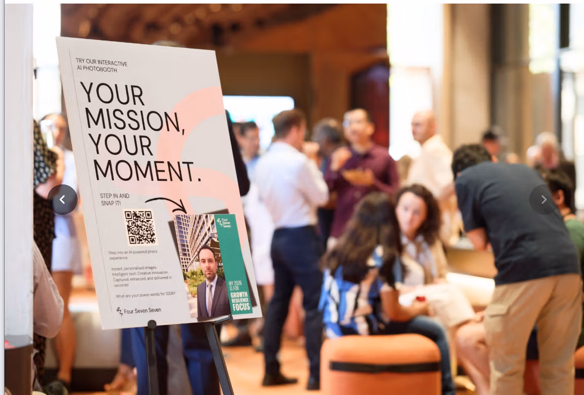 An AI Photobooth stand with "YOUR MISSION, YOUR MOMENT." branding for Four Seven Seven, at a bustling CBRE event