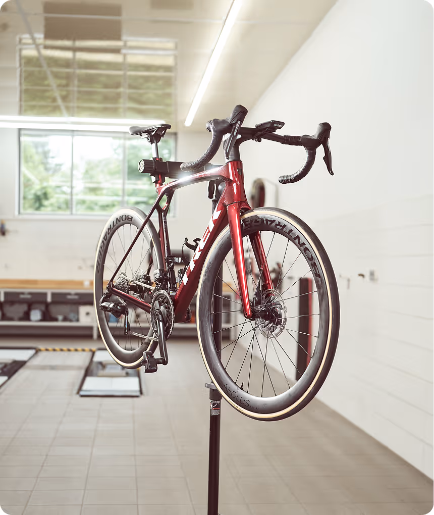 Fahrrad steht auf einem Ständer in der hellen Schadenprüfhalle zur Begutachtung