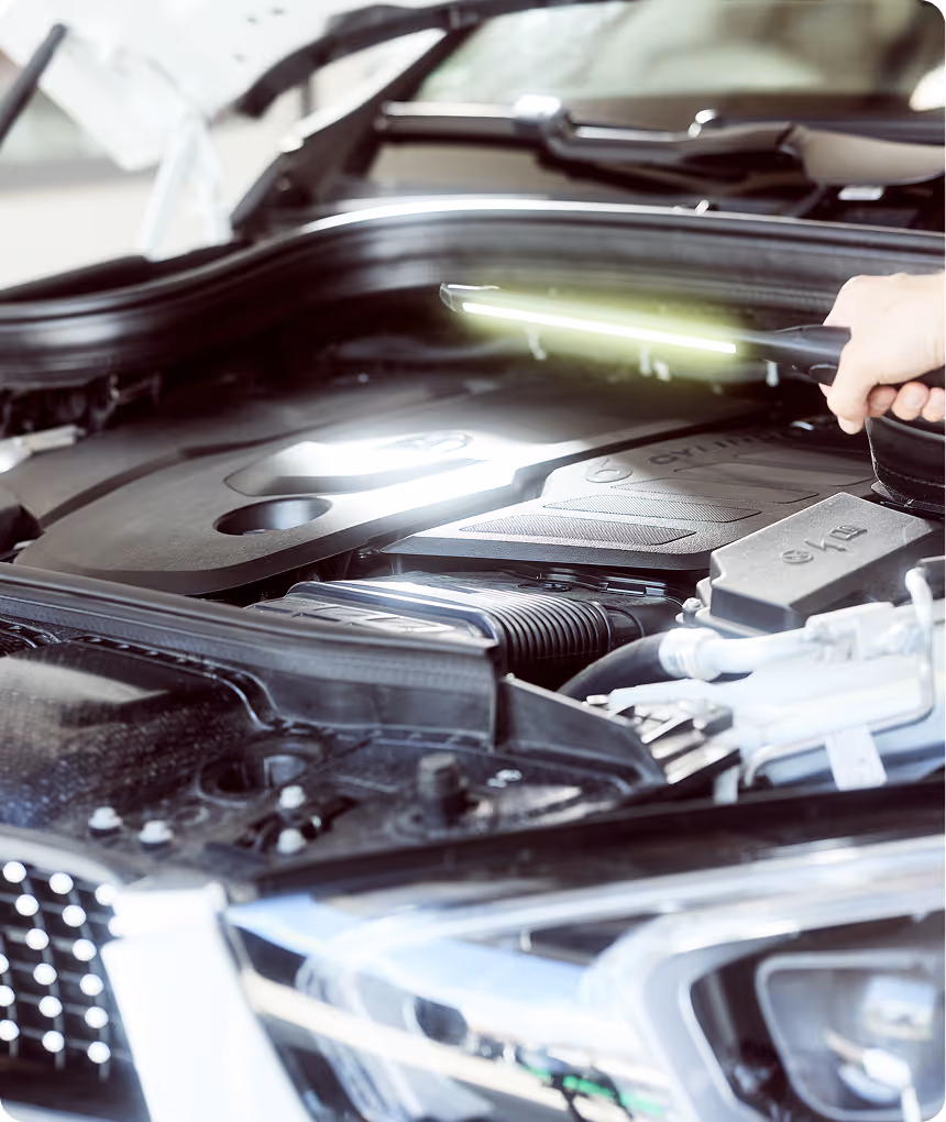 Blick in den geöffneten Motorraum eines Autos bei der Fahrzeugbewertung