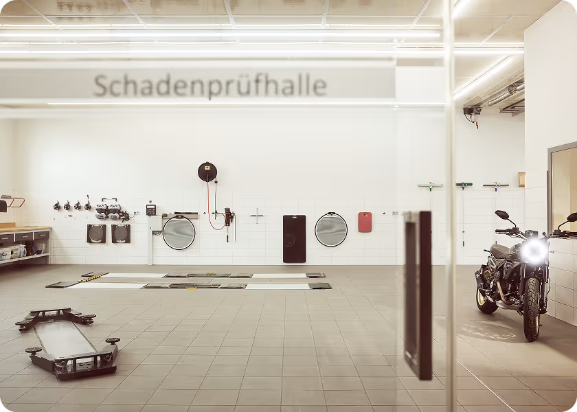Blick in die moderne Werkstatt mit heller Schadenprüfhalle und Arbeitsbereichen für Fahrzeuguntersuchungen