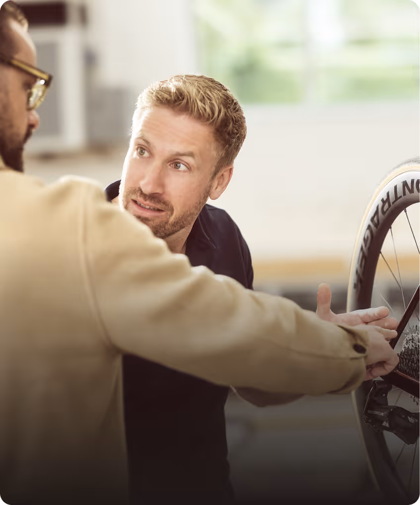 KFZ-Sachverständiger erläutert einem Kunden die Schadensbewertung an einem Fahrrad im Rahmen eines Fahrradgutachtens.